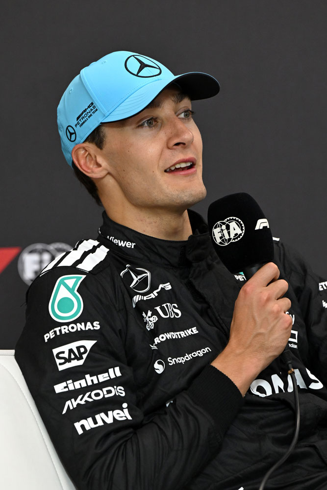 Formel 1-køreren George Russell med en mikrofon i sin højre hånd.
