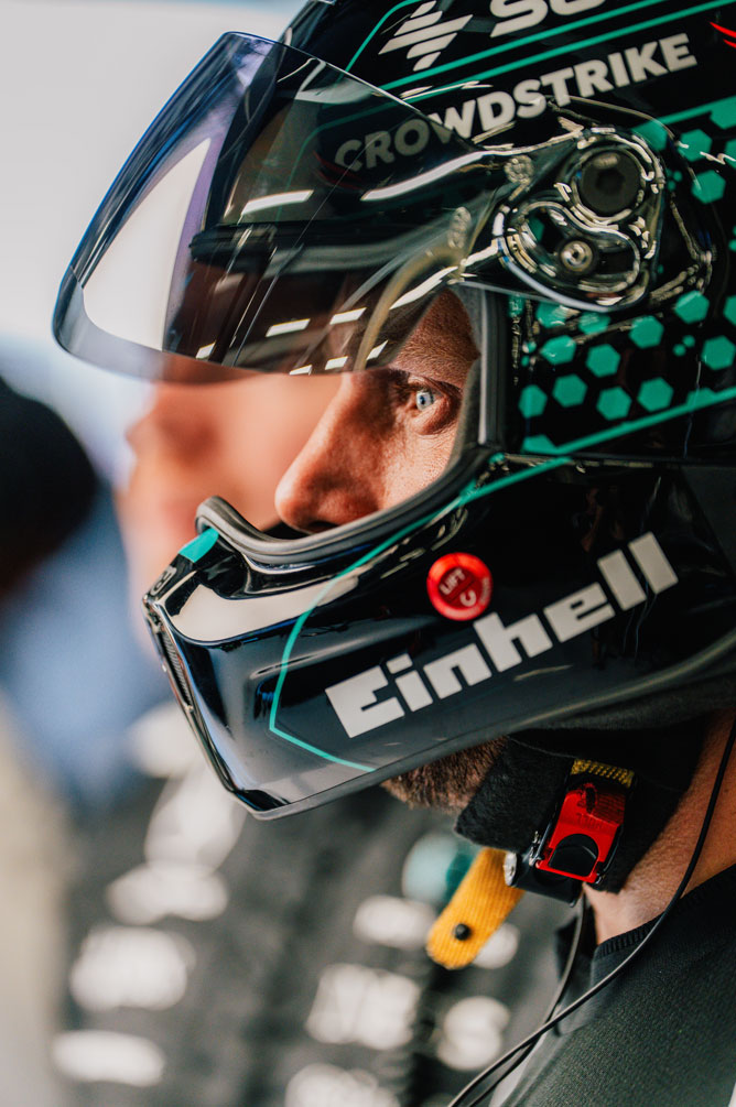 Et Formel 1-crewmedlem har hjelm på og kigger fokuseret til siden.