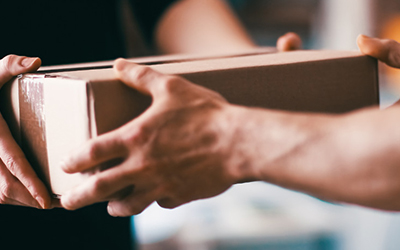 A person handing over a package to another person. 